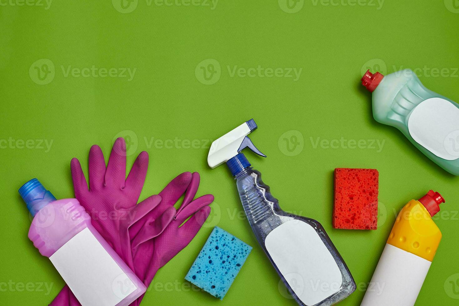 Detergents and cleaning accessories on a green background. Housekeeping concept. photo