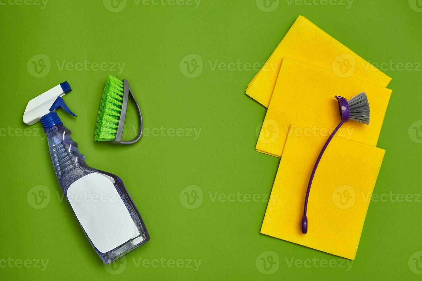 Detergents and cleaning accessories on a green background. Housekeeping concept. photo