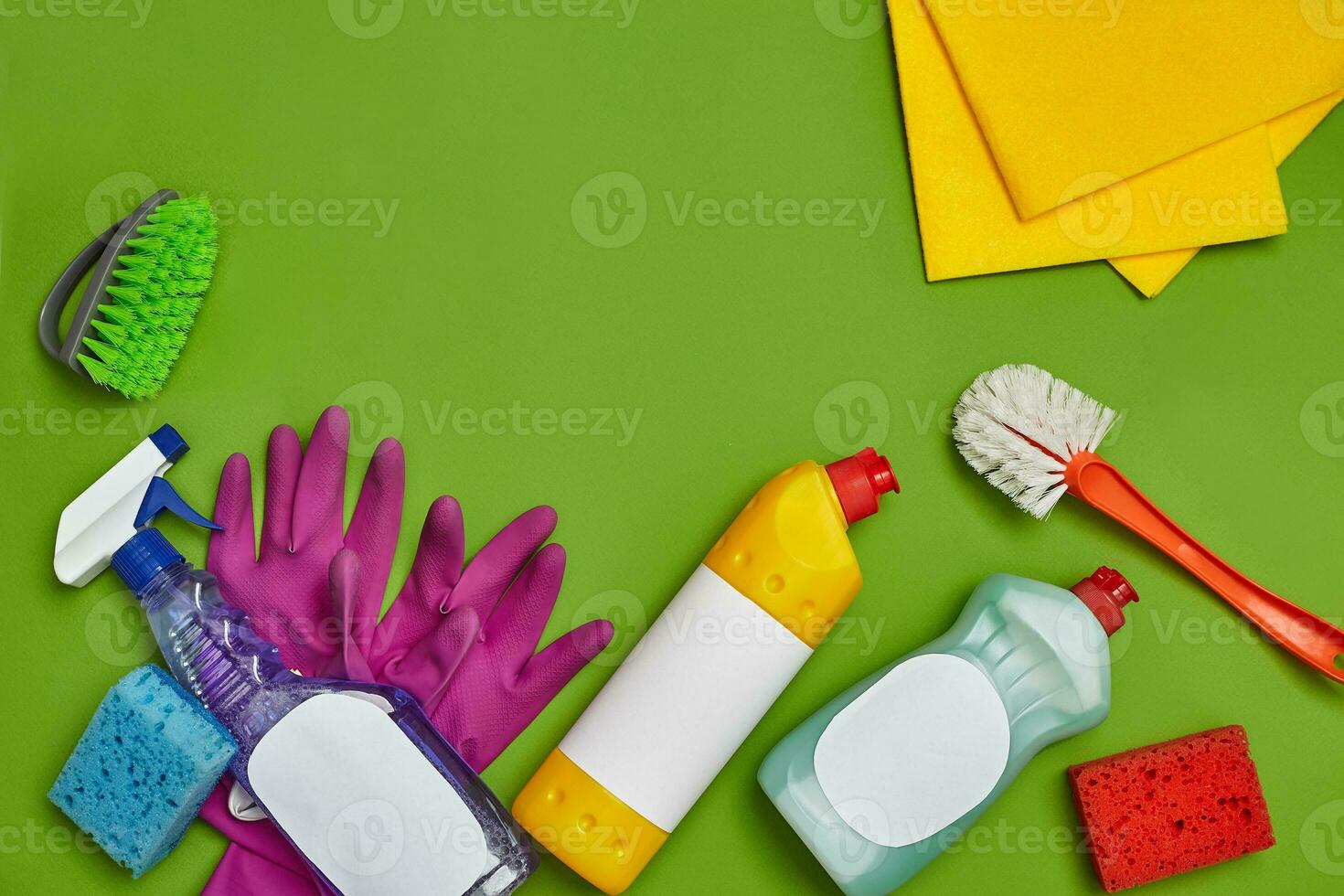 Detergents and cleaning accessories on a green background. Housekeeping concept. photo