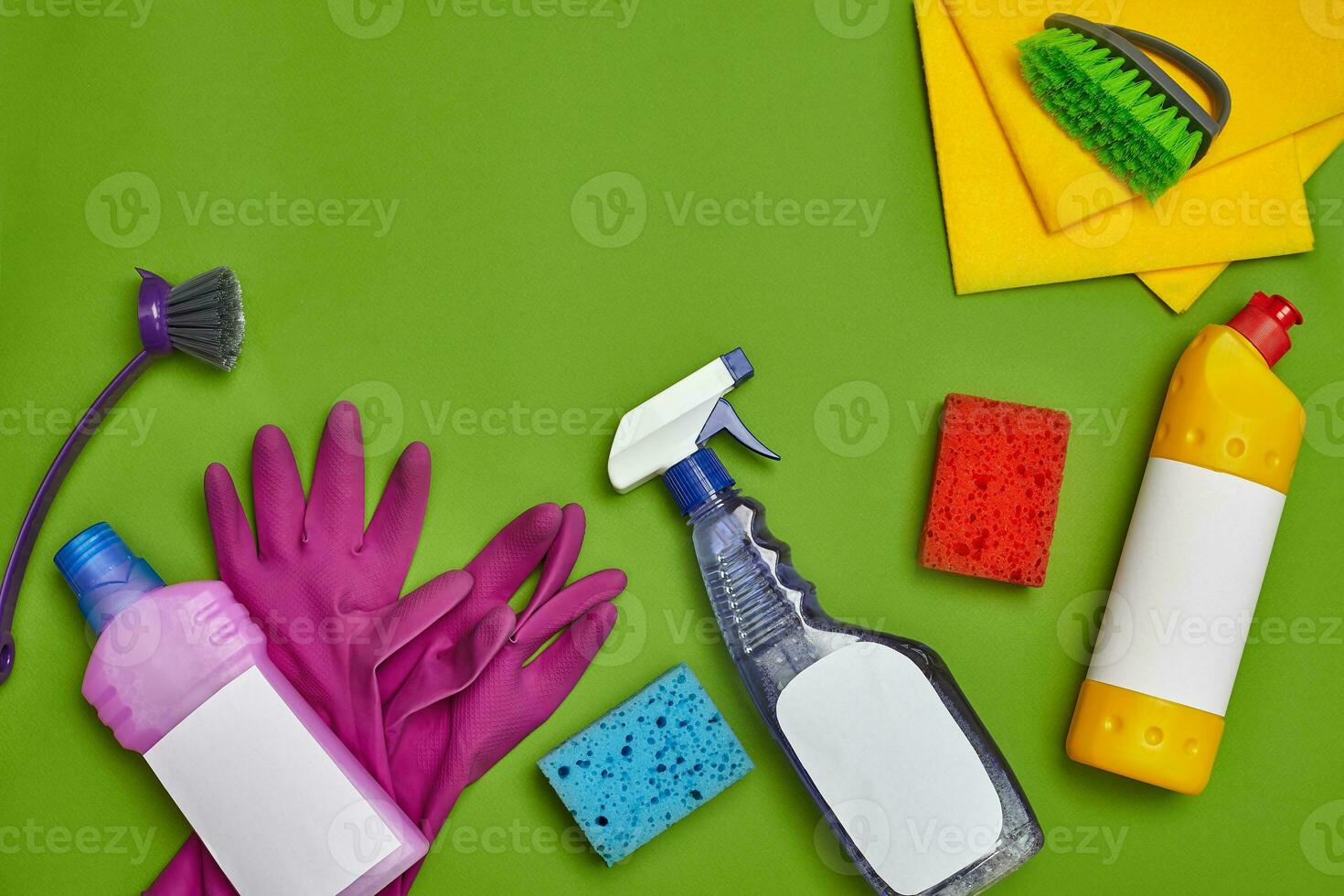 Detergents and cleaning accessories on a green background. Housekeeping concept. photo