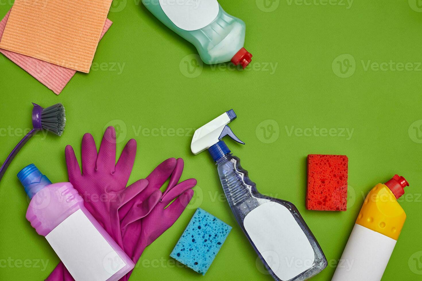 Detergents and cleaning accessories on a green background. Housekeeping concept. photo