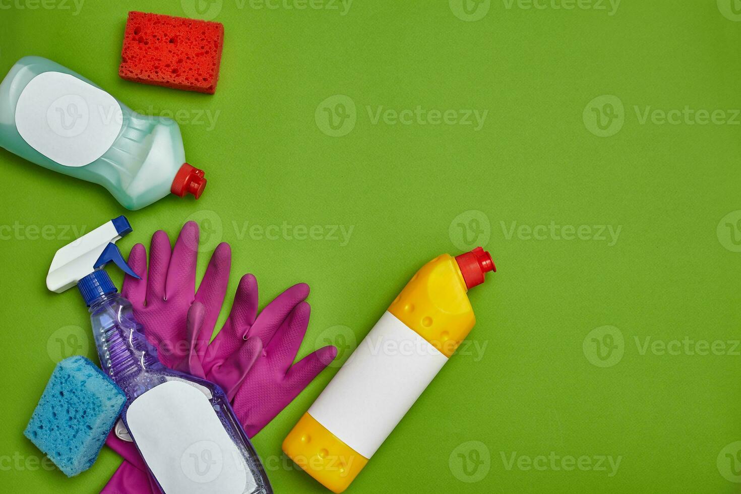 Detergents and cleaning accessories on a green background. Housekeeping concept. photo