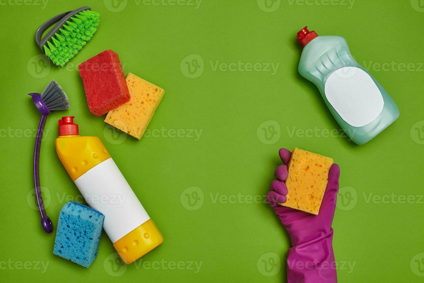 Detergents and cleaning accessories on a green background. Housekeeping concept. photo