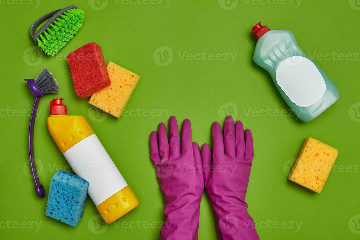 Detergents and cleaning accessories on a green background. Housekeeping concept. photo