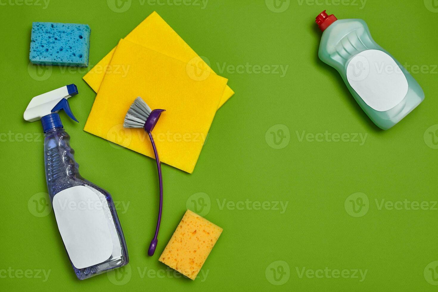 Detergents and cleaning accessories on a green background. Housekeeping concept. photo