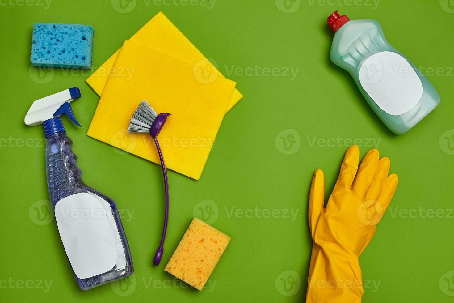 Detergents and cleaning accessories on a green background. Housekeeping concept. photo