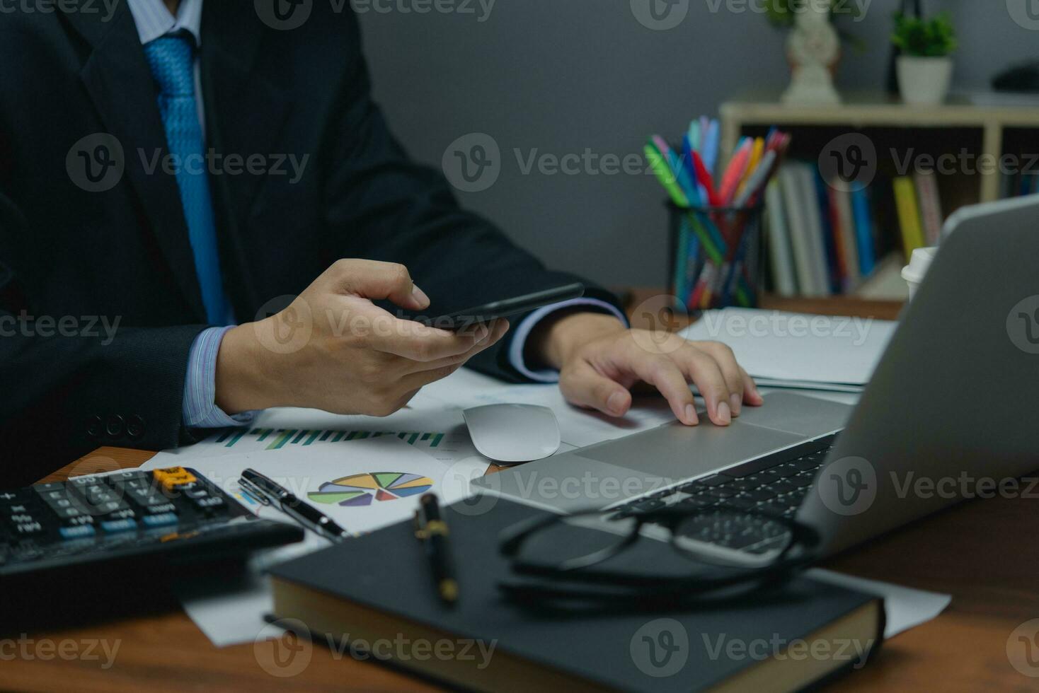Business man using mobile smart phone management information , marketing online digital technology working in corporate office on desk. photo