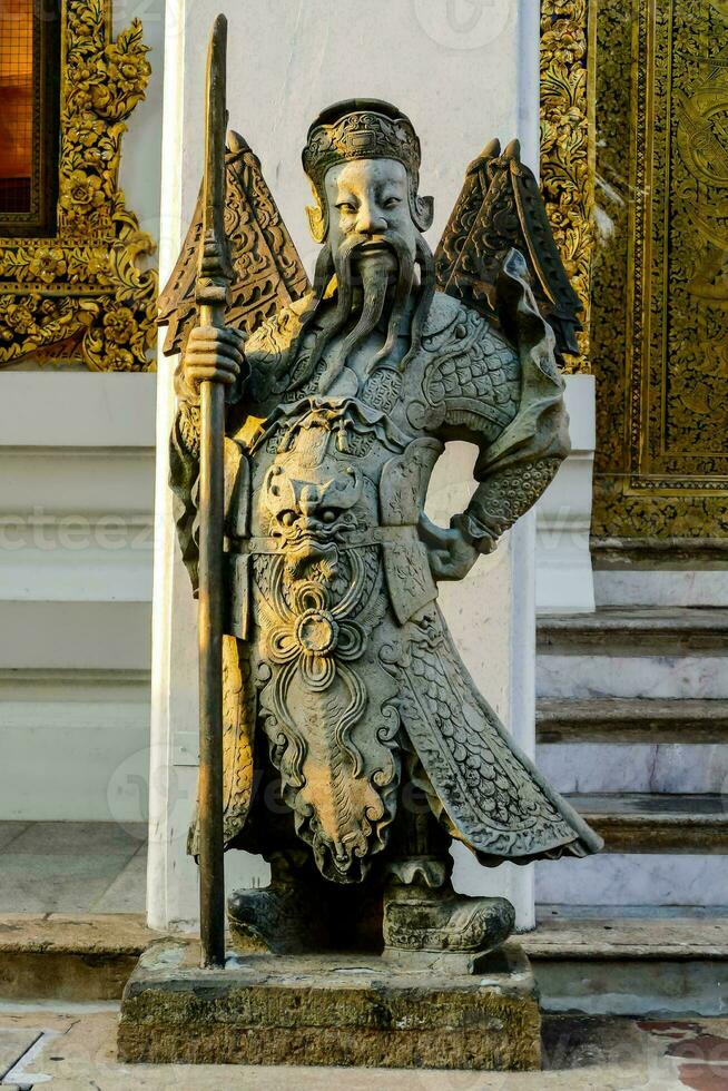 a statue of an asian man holding a stick photo