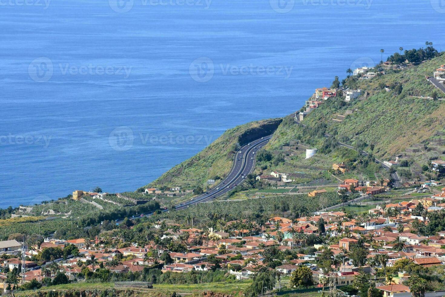 a city on the side of a hill overlooking the ocean photo