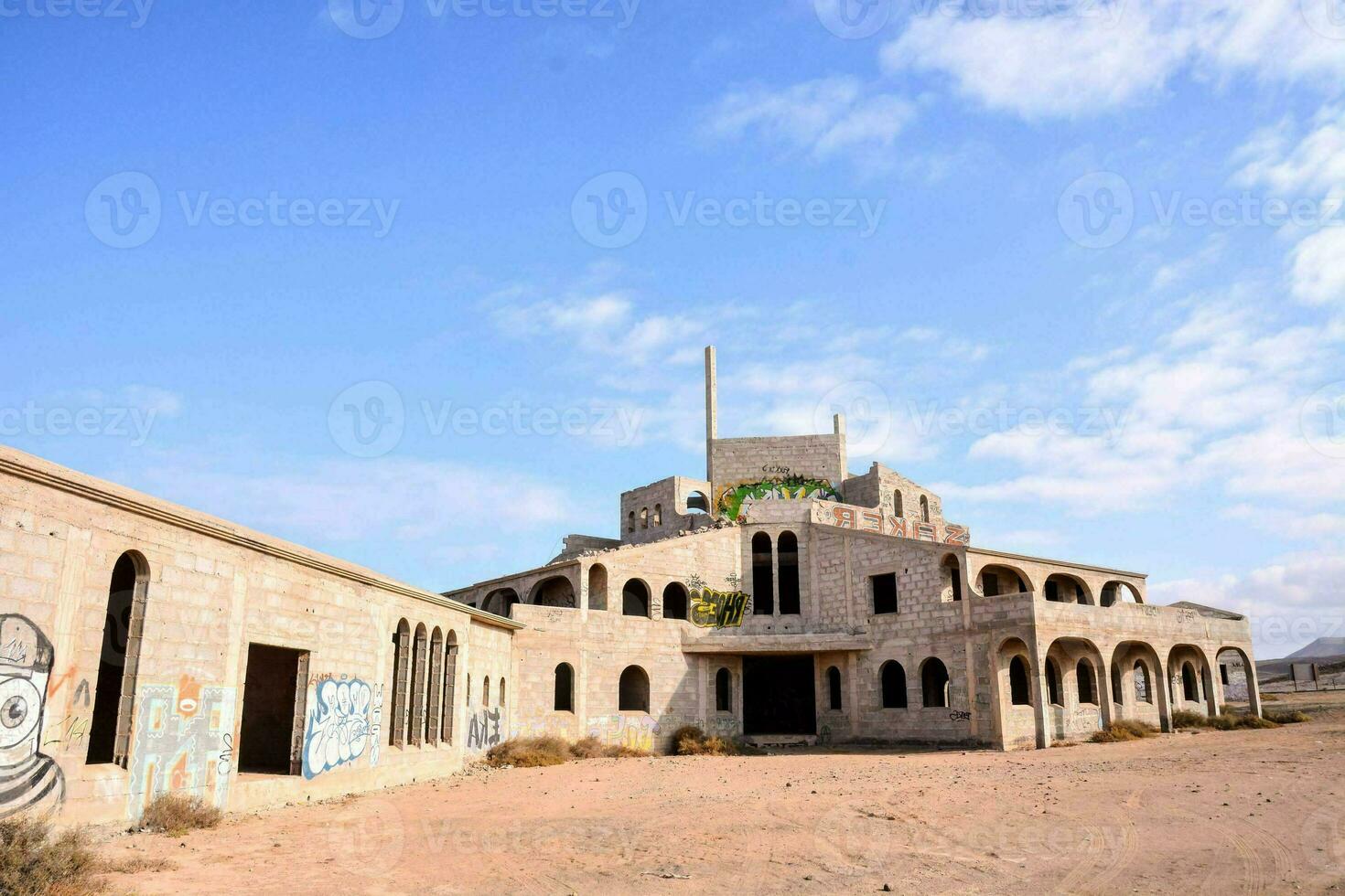 abandoned building in the desert with graffiti on the walls photo