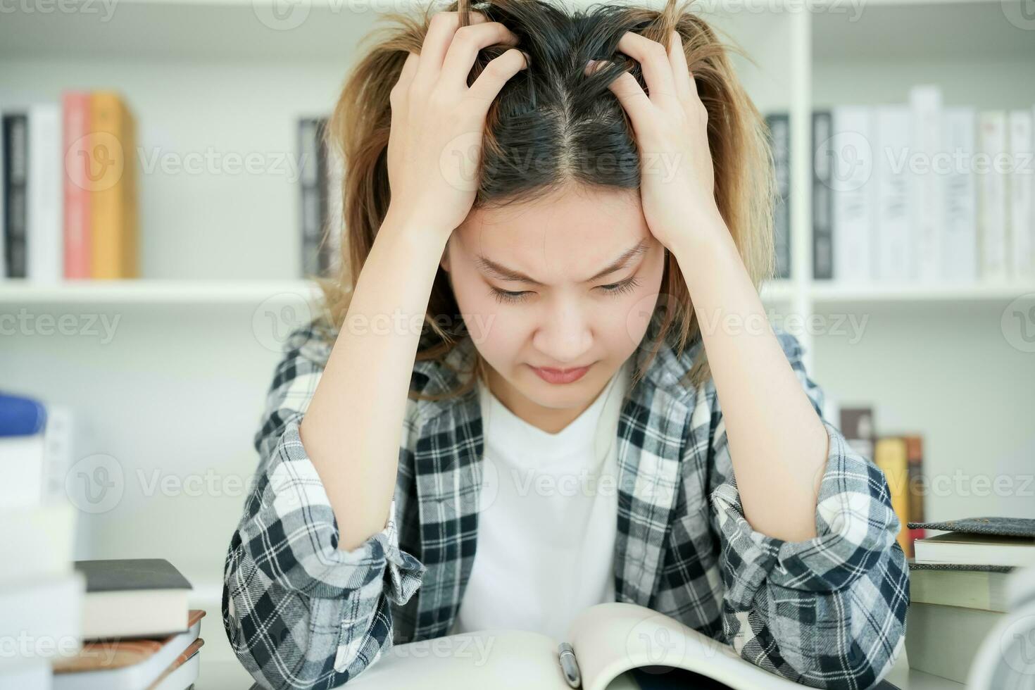 Asian student woman have anxiety because of exams, female prepare for test and learning lessons in the library. stress, despair, haste, misunderstanding reading, discouraged, expectation, knowledge photo