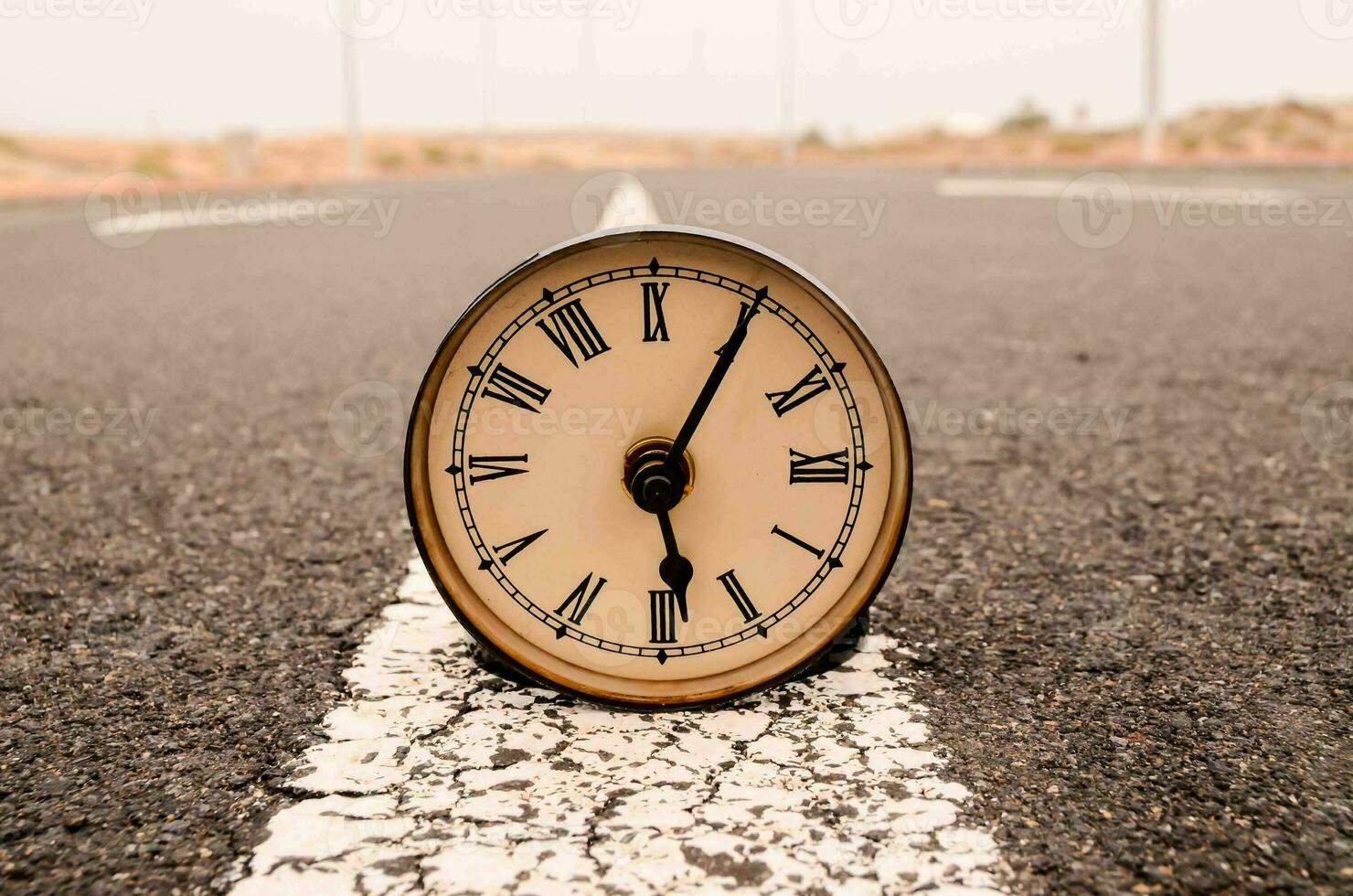 a clock is sitting on the side of a road photo