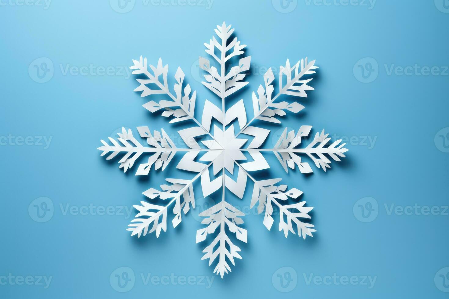 Beautiful DIY paper snowflakes in mid creation isolated on a blue gradient background photo