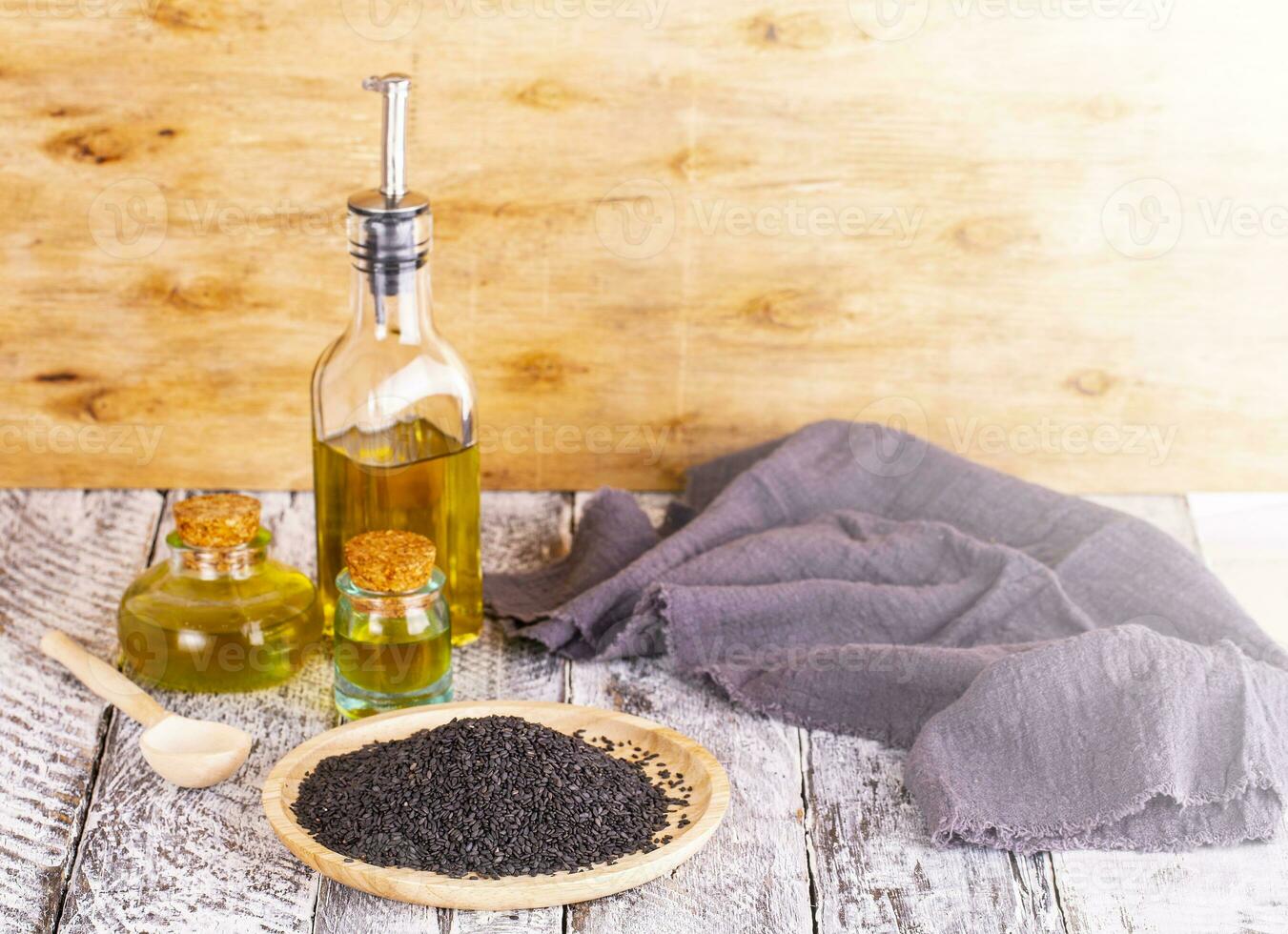 oil and sesame seeds on wooden surface photo