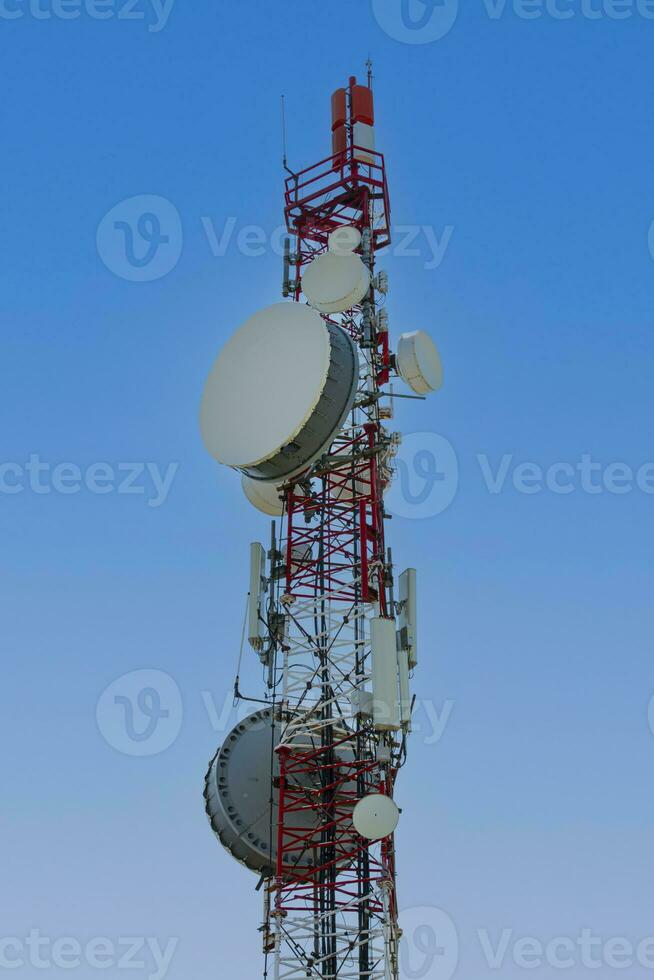 cell tower with antenna against blue sky photo