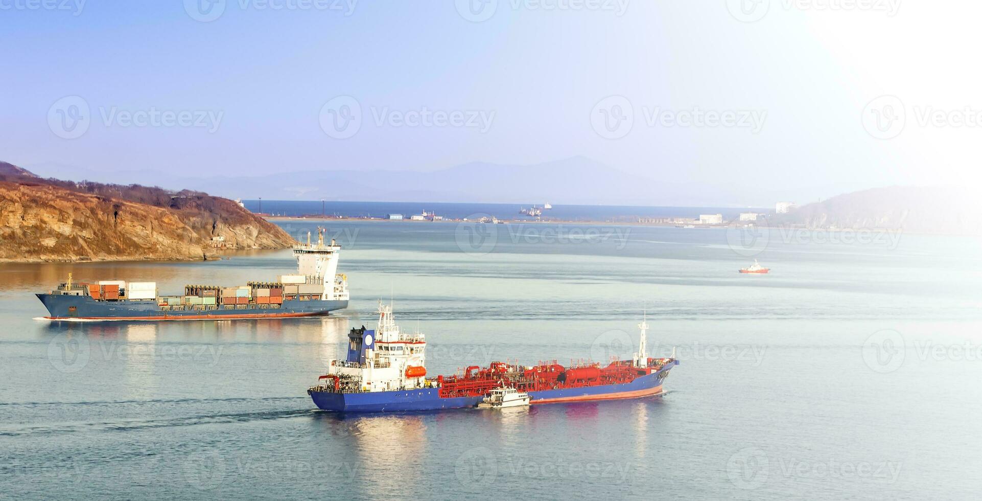 Selective focus. The Large container ship and reefer ship at blue sea in soft sunlight photo