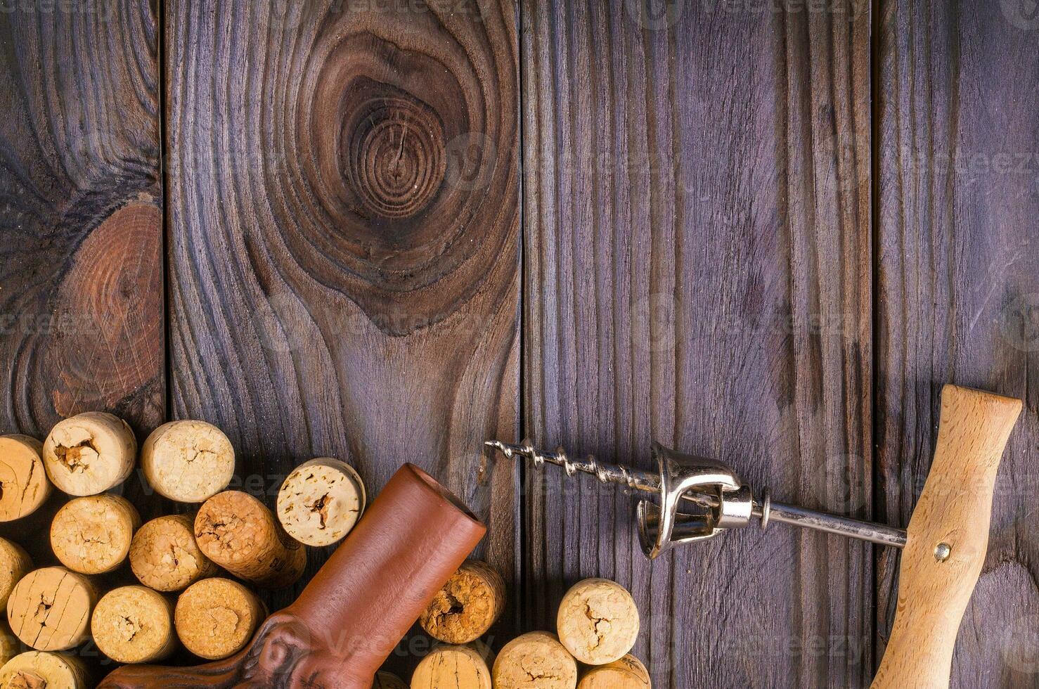 bottle of wine with corks on wooden table background photo