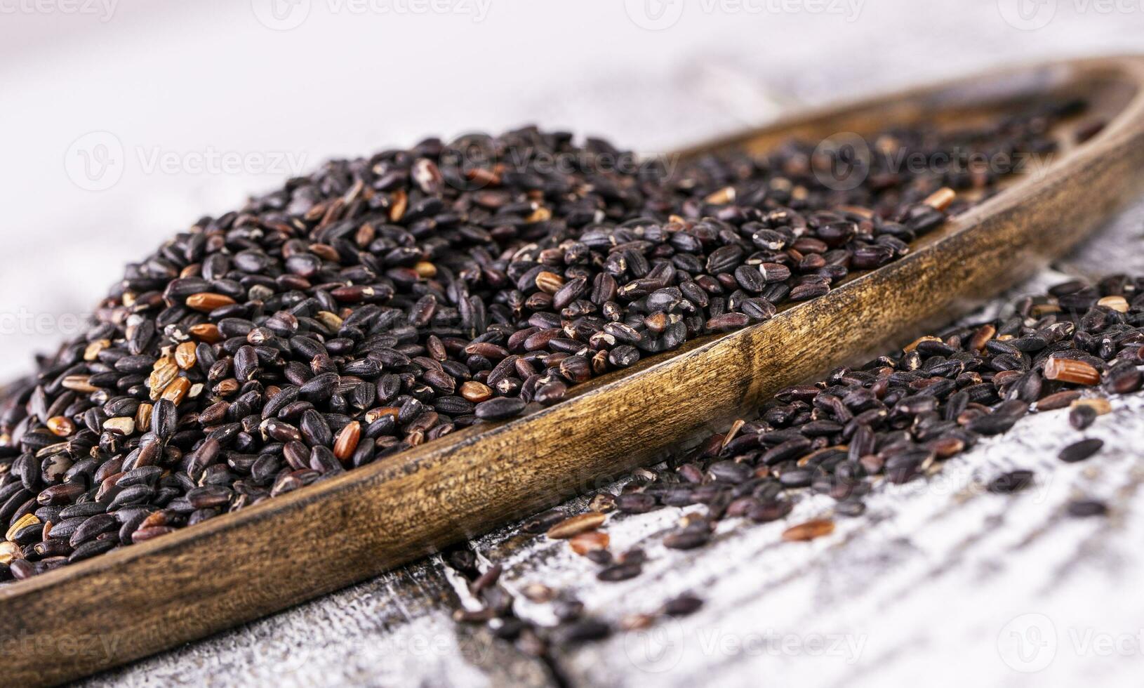 Close up of black rice on wooden surface photo
