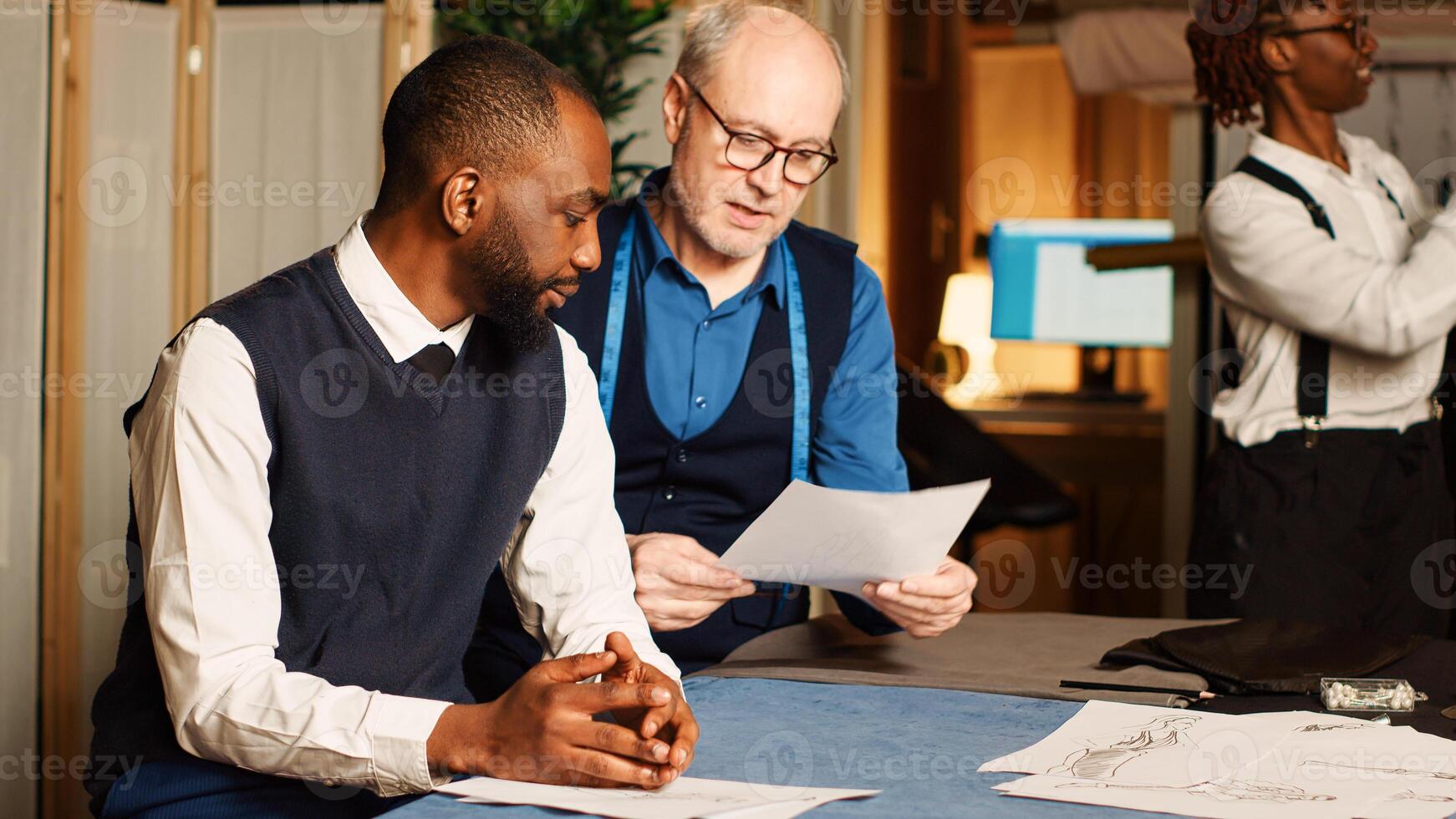 Professional tailor measuring client to create luxury tailored suit in atelier workshop. Experienced couturier takes measurements to manufacture clothing items for customer, handcraft. photo