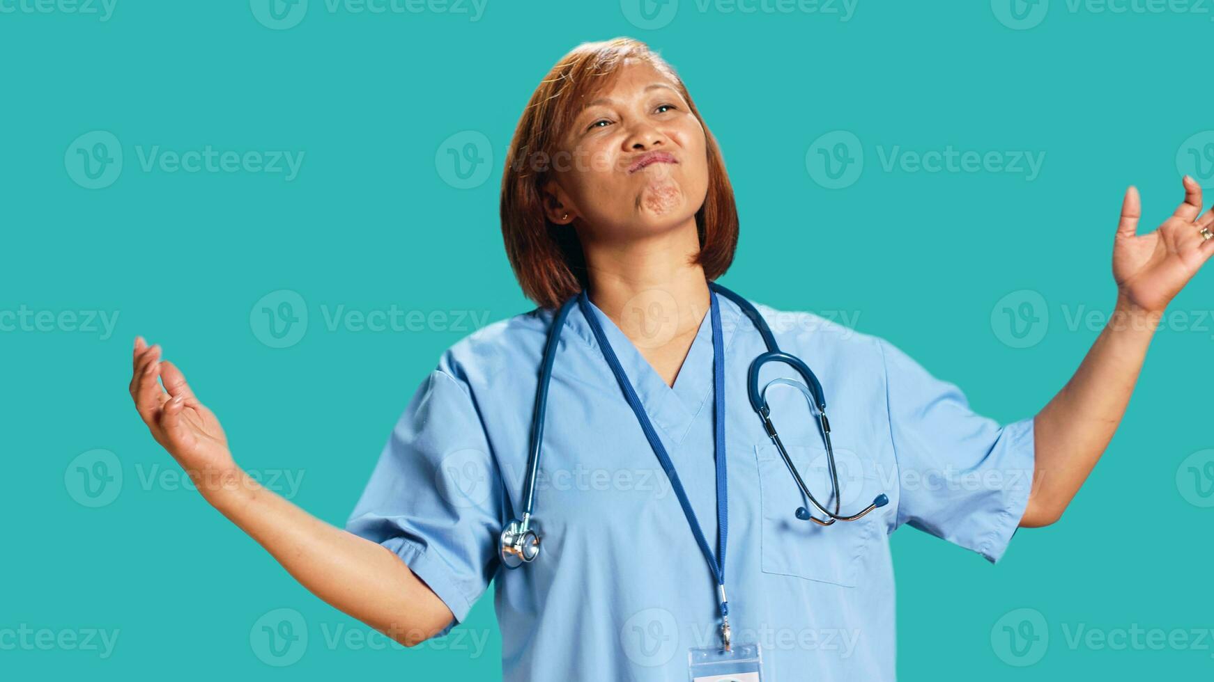 Close up shot of conflicted BIPOC nurse doing perplexed gesturing while at work. Baffled perplexed healthcare specialist taken aback by what she hears, isolated over studio background photo