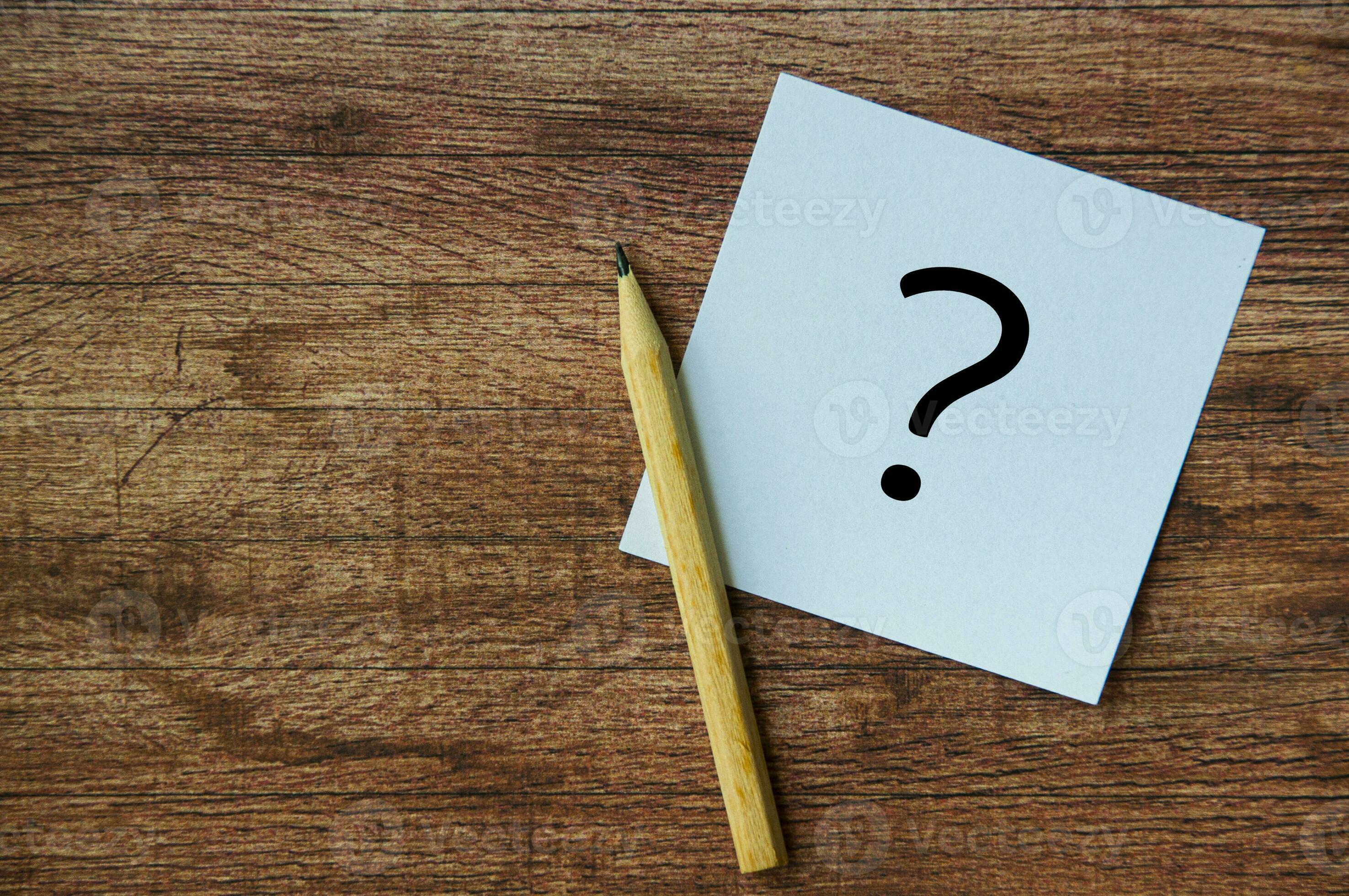 Top view of question mark on notepad with pencil. Question and answer
