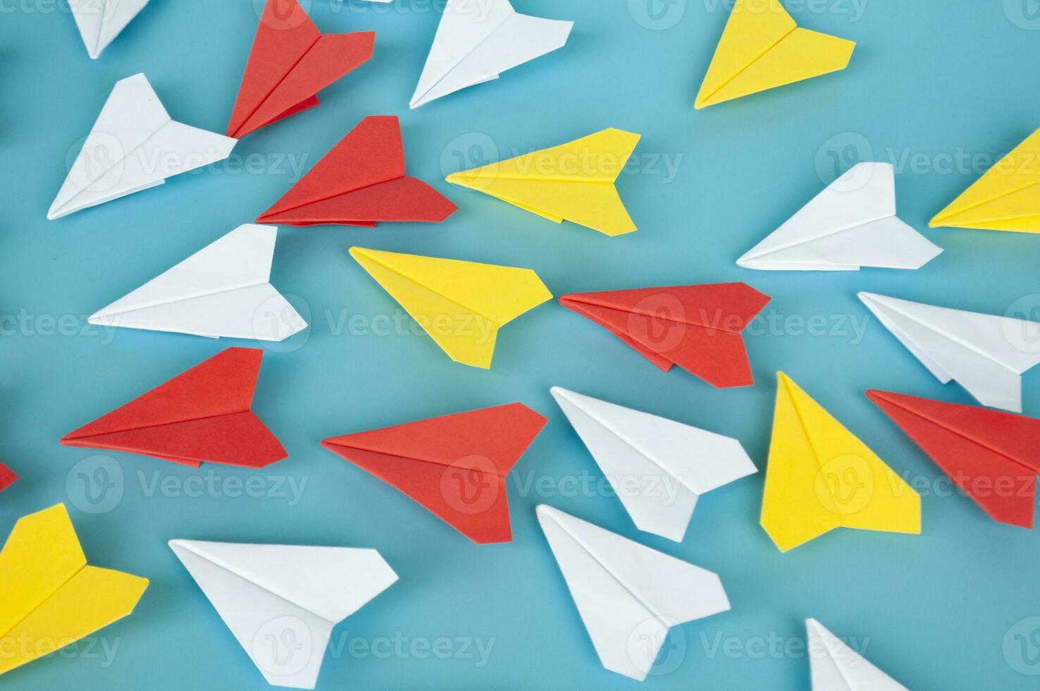 Yellow paper plane origami leading other white paper planes on blue background. Leadership concept. Origami concept. photo