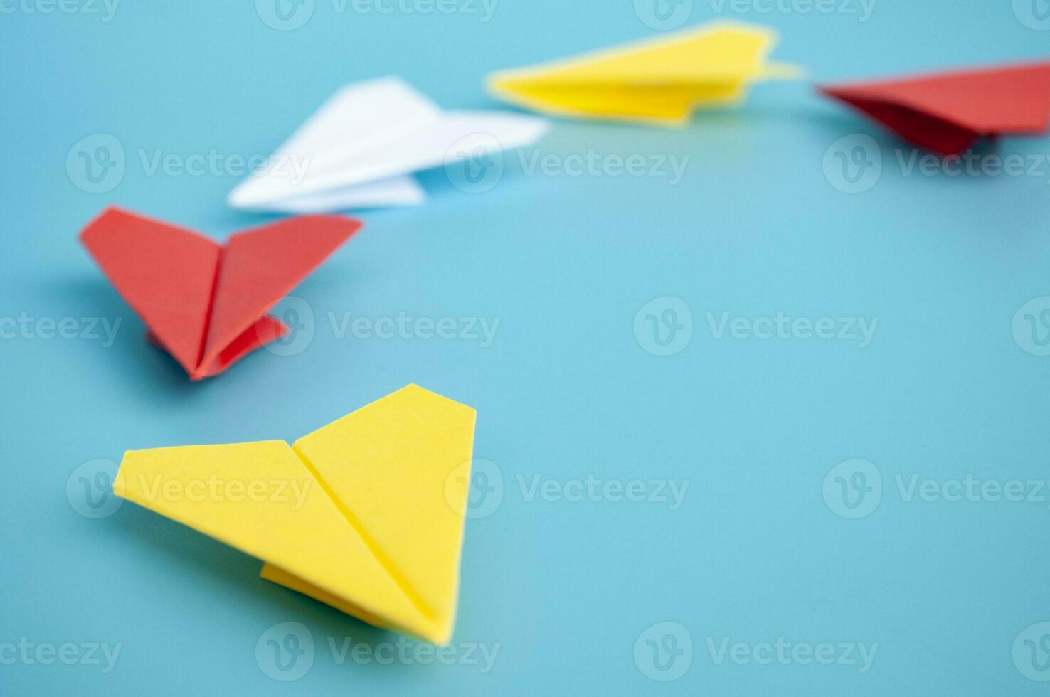 amarillo papel avión origami líder otro papel aviones en azul antecedentes. liderazgo y Copiar espacio. foto