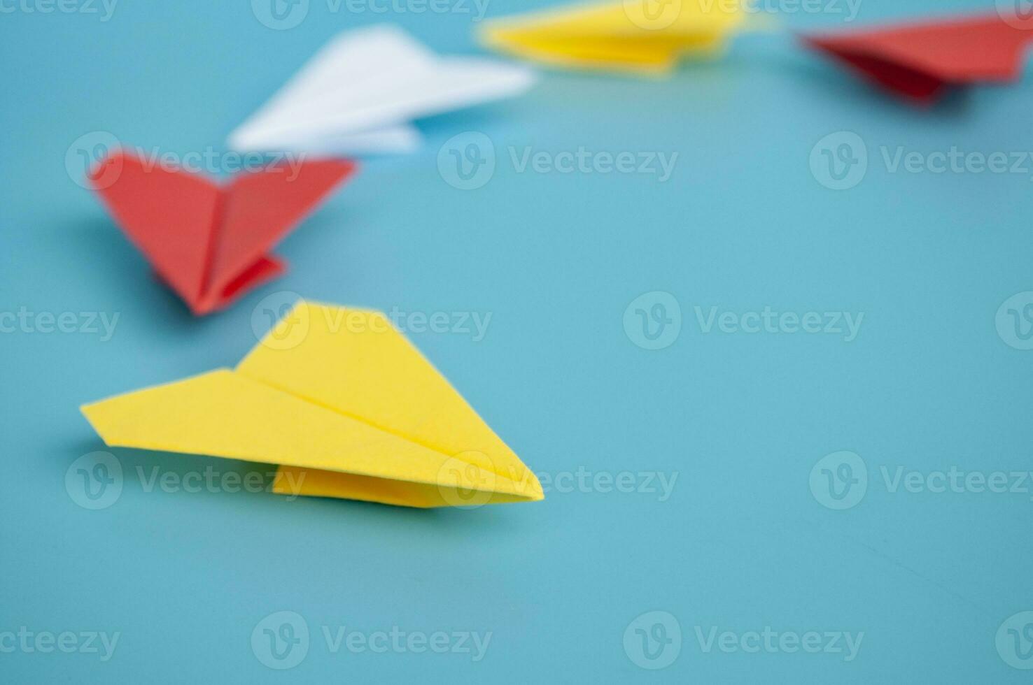amarillo papel avión origami líder otro papel aviones en azul antecedentes. liderazgo concepto. foto