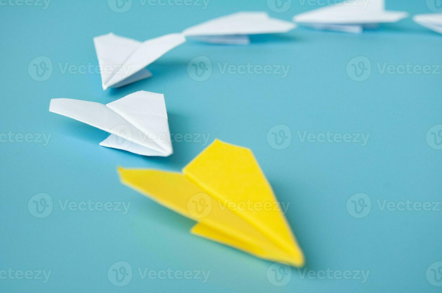 Side view of yellow paper airplane origami leading white paper airplanes. Leadership and copy space concept photo