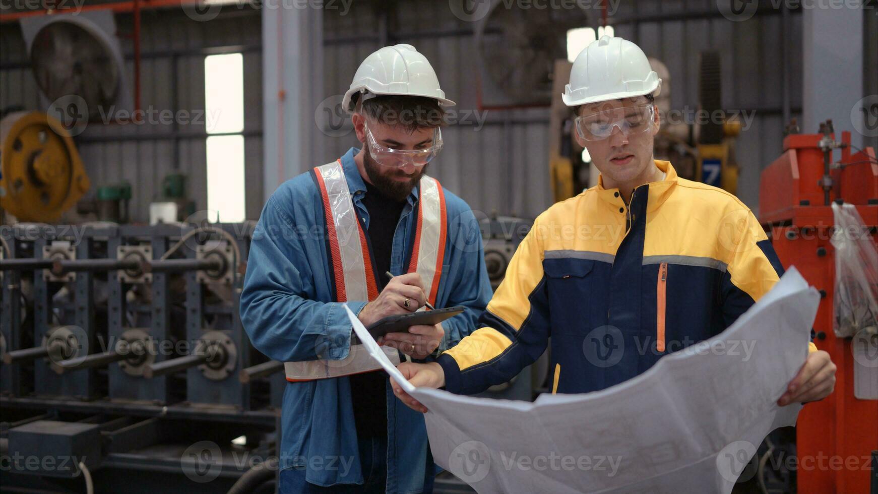 Team of engineers and architects working with blueprint at factory site. It is a massive new facility for making metal sheets as well as a transportation and distribution warehouse. photo