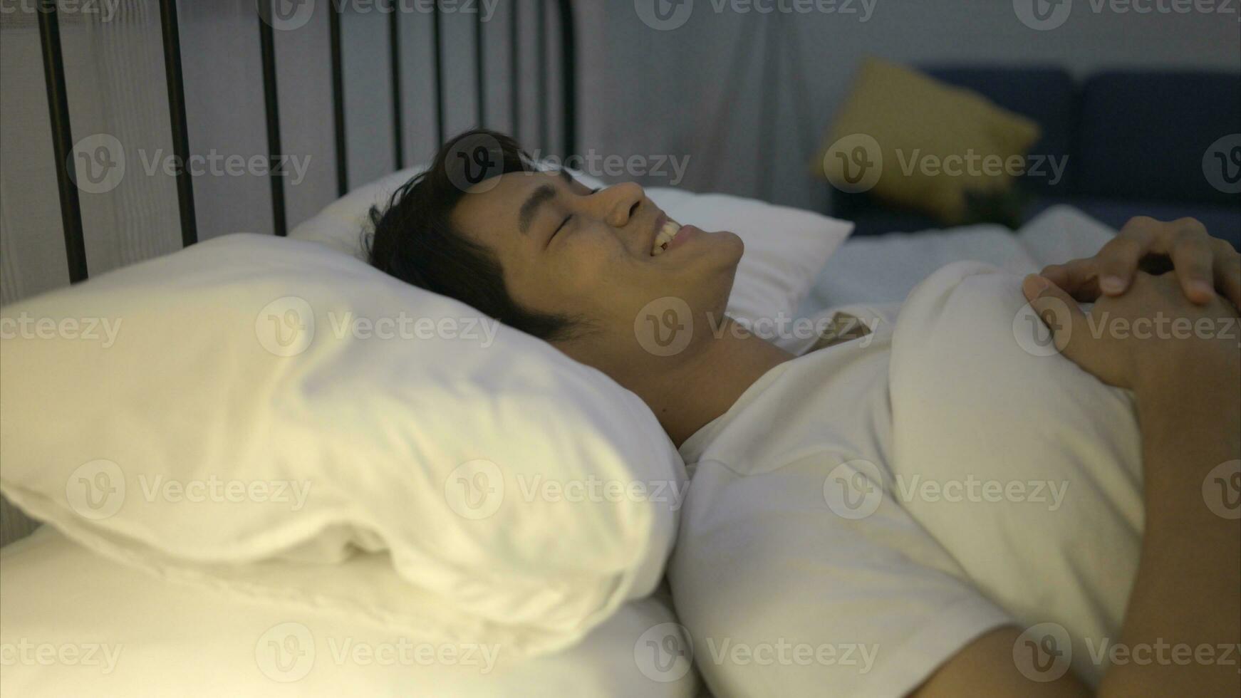 A young Asian man sleeps comfortably with a soft pillow. photo