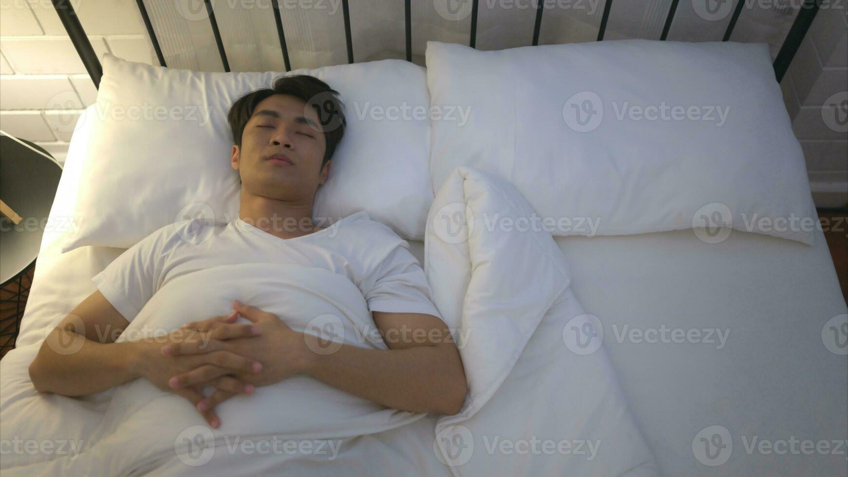 Young Asian man lying on the bed Use his hand to fumble his wife who thinks her woke up together that morning. photo