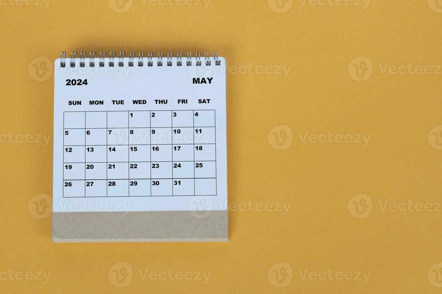 May 2024 desk calendar on yellow background. Directly above. Flat lay. photo
