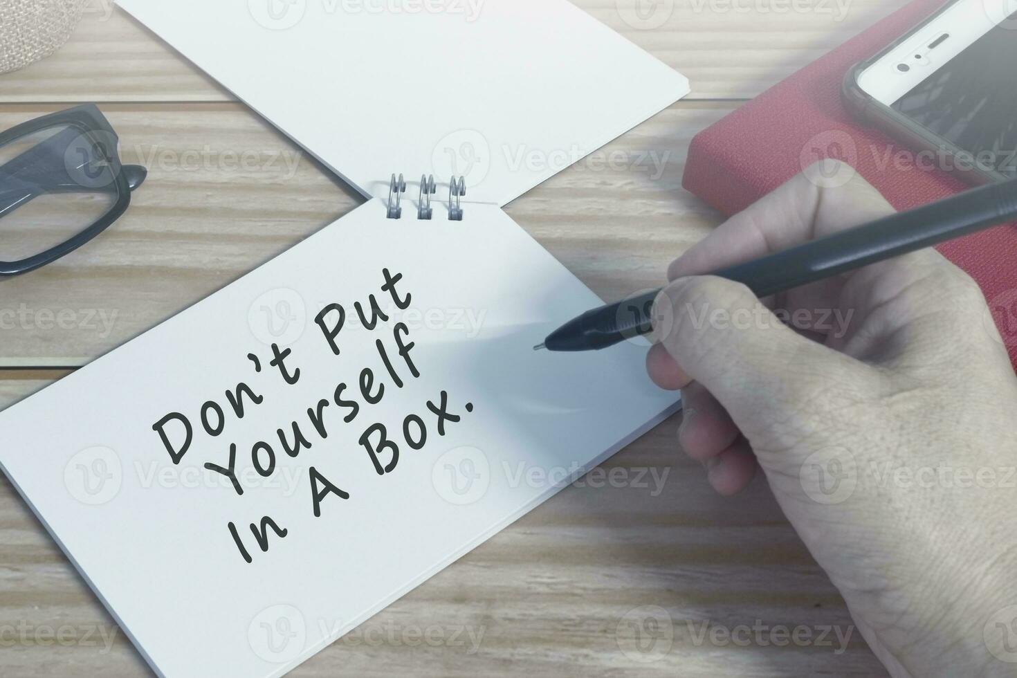 Motivational quote on notepad. Do not put yourself in a box. photo