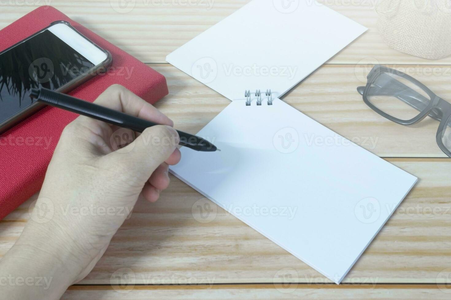 Hand with pen writing on the black clipboard. Copy space. photo