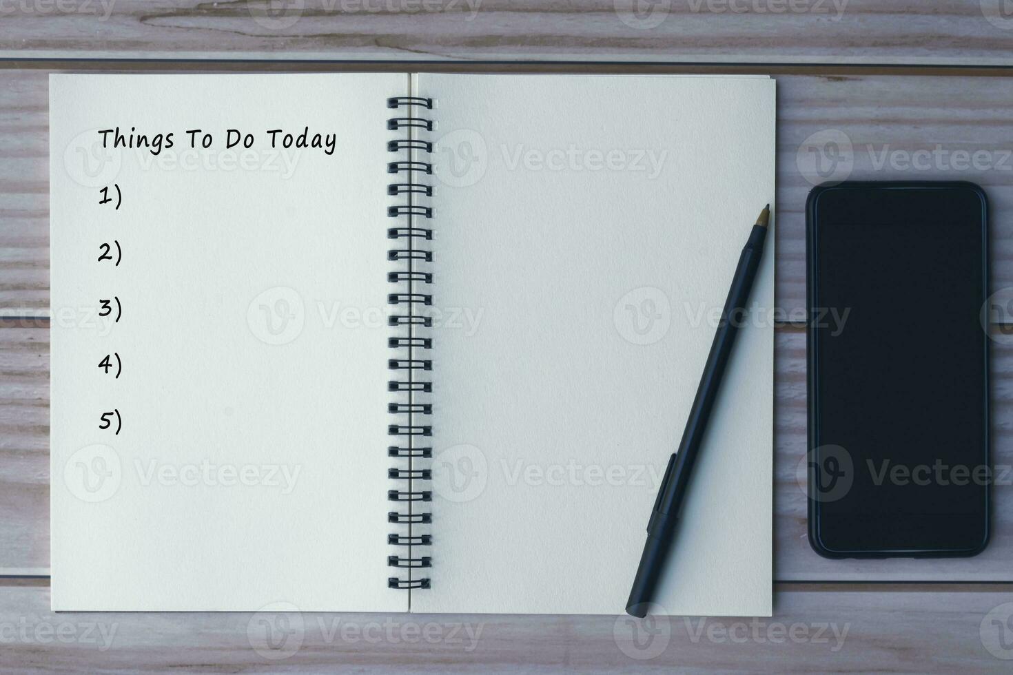 Notebook with things to do today list on wooden desk with pen and smartphone. photo