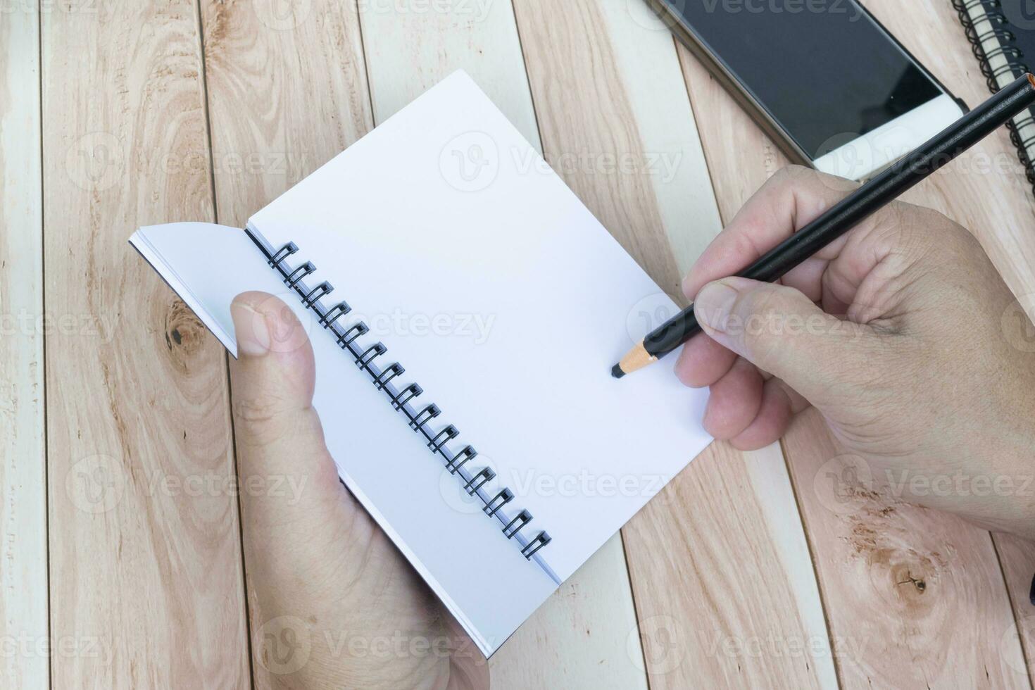 Businessman hands with pen writing notebook on office desk. Copy space. photo