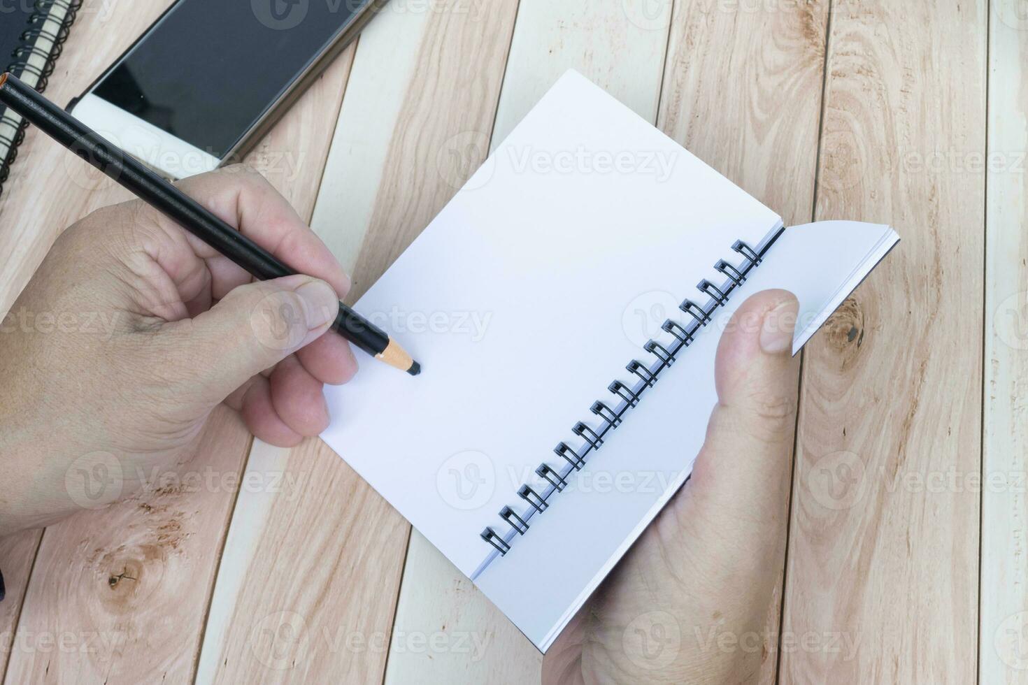 Businessman hands with pen writing notebook on office desk. Copy space. photo