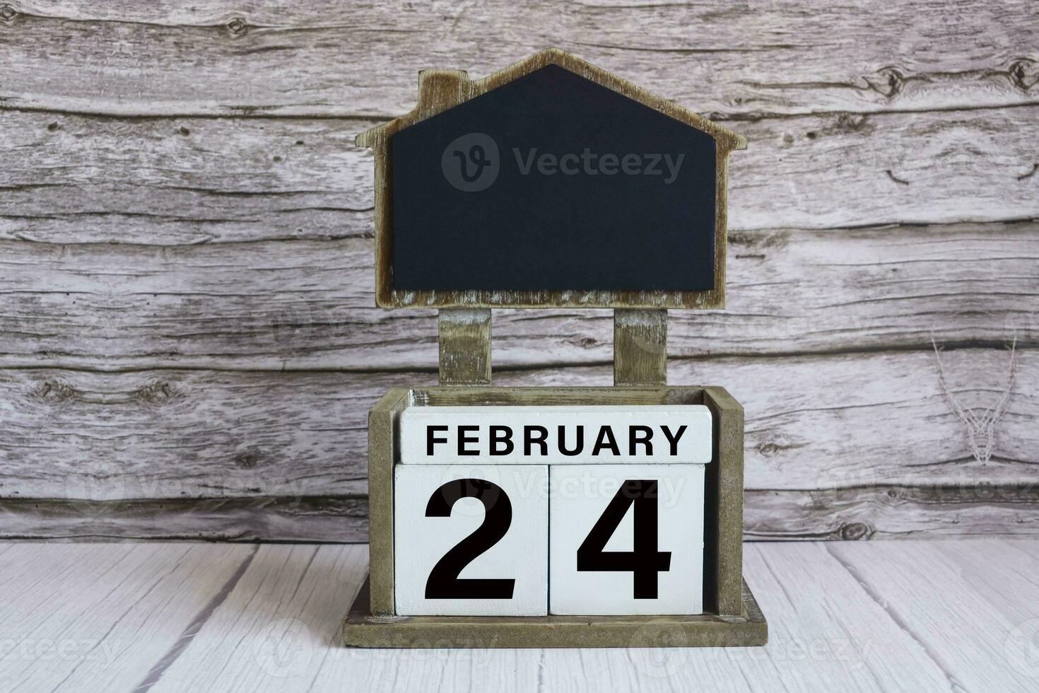 Chalkboard with date on white cube block on wooden table. photo