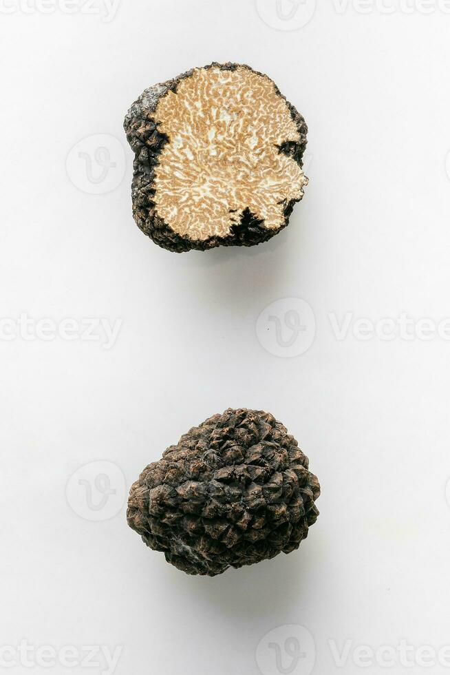 Macro shot of black truffle mushroom full and cut isolated on white background photo