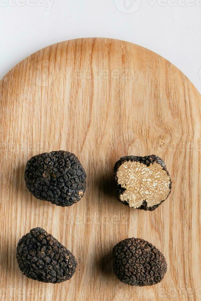 Black truffle mushroom close up on wooden plate photo