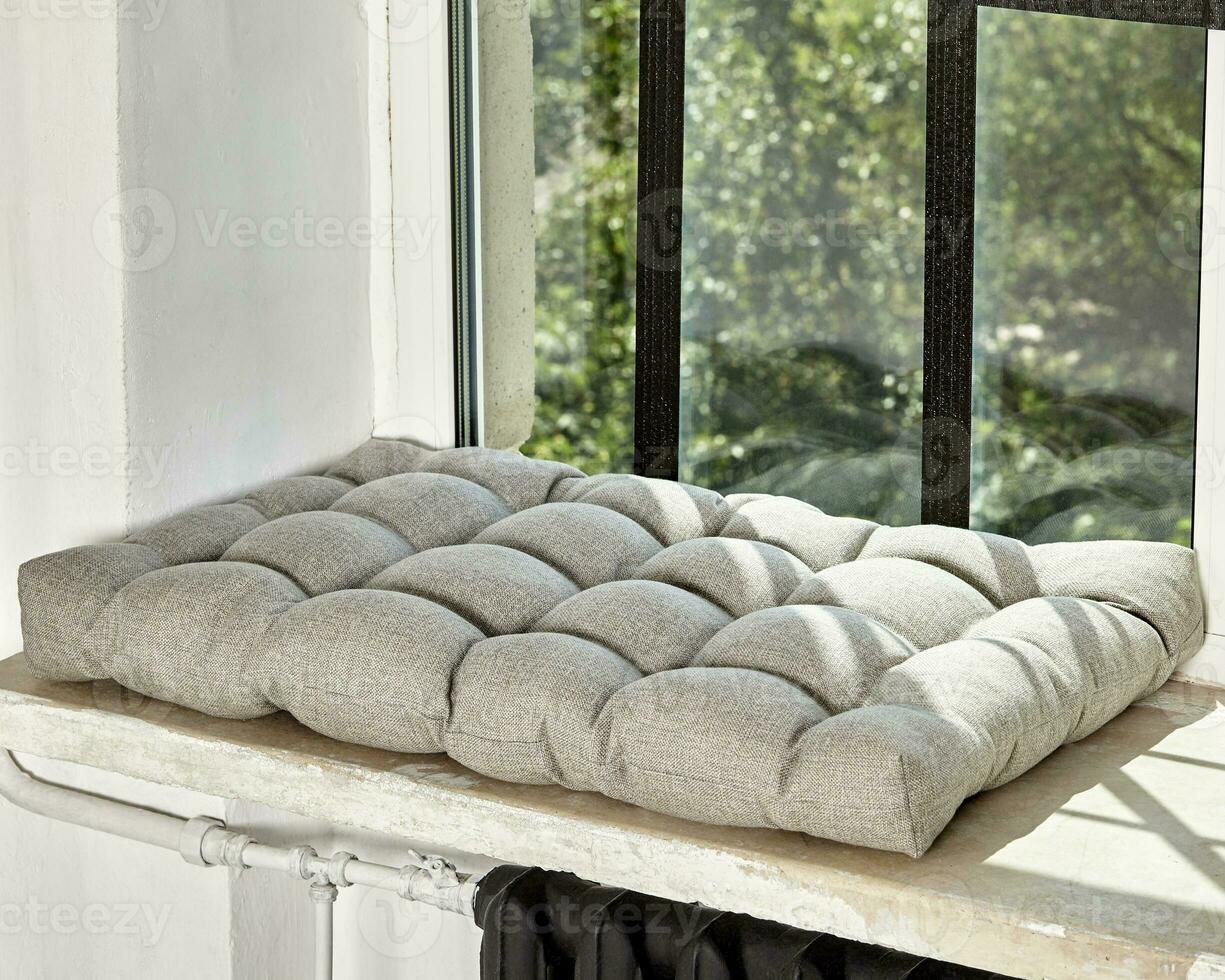 Soft Scandinavian style gray cushion lying on windowsill photo