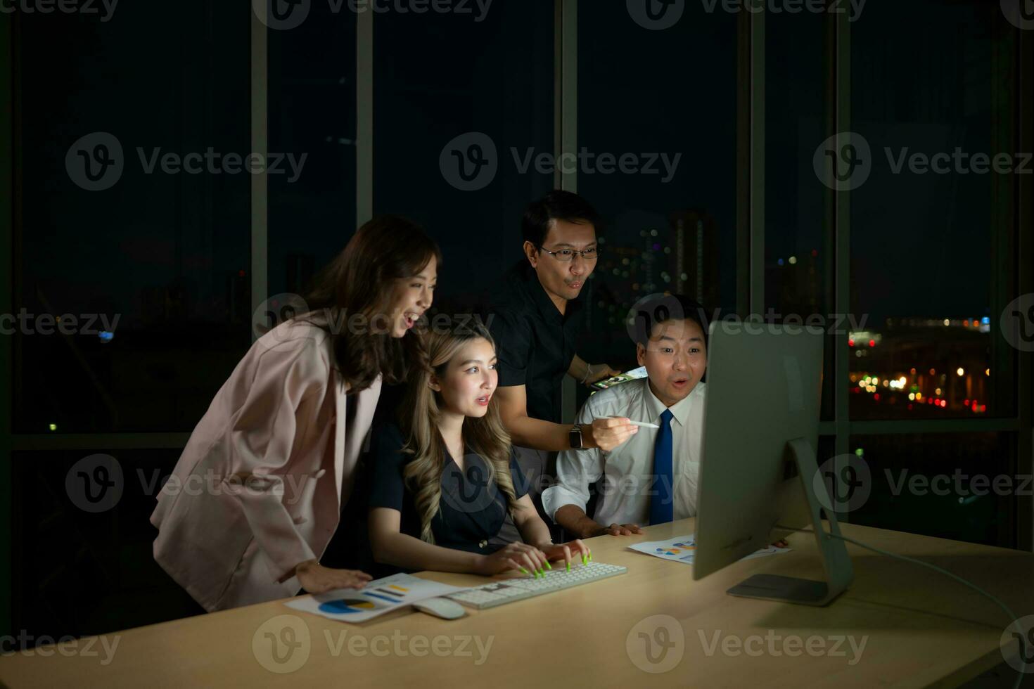 Group of business people working in office at night. Business concept. photo