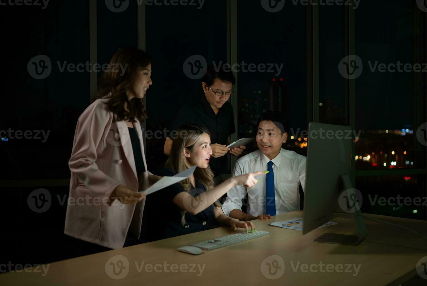 Group of business people working in office at night. Business concept. photo