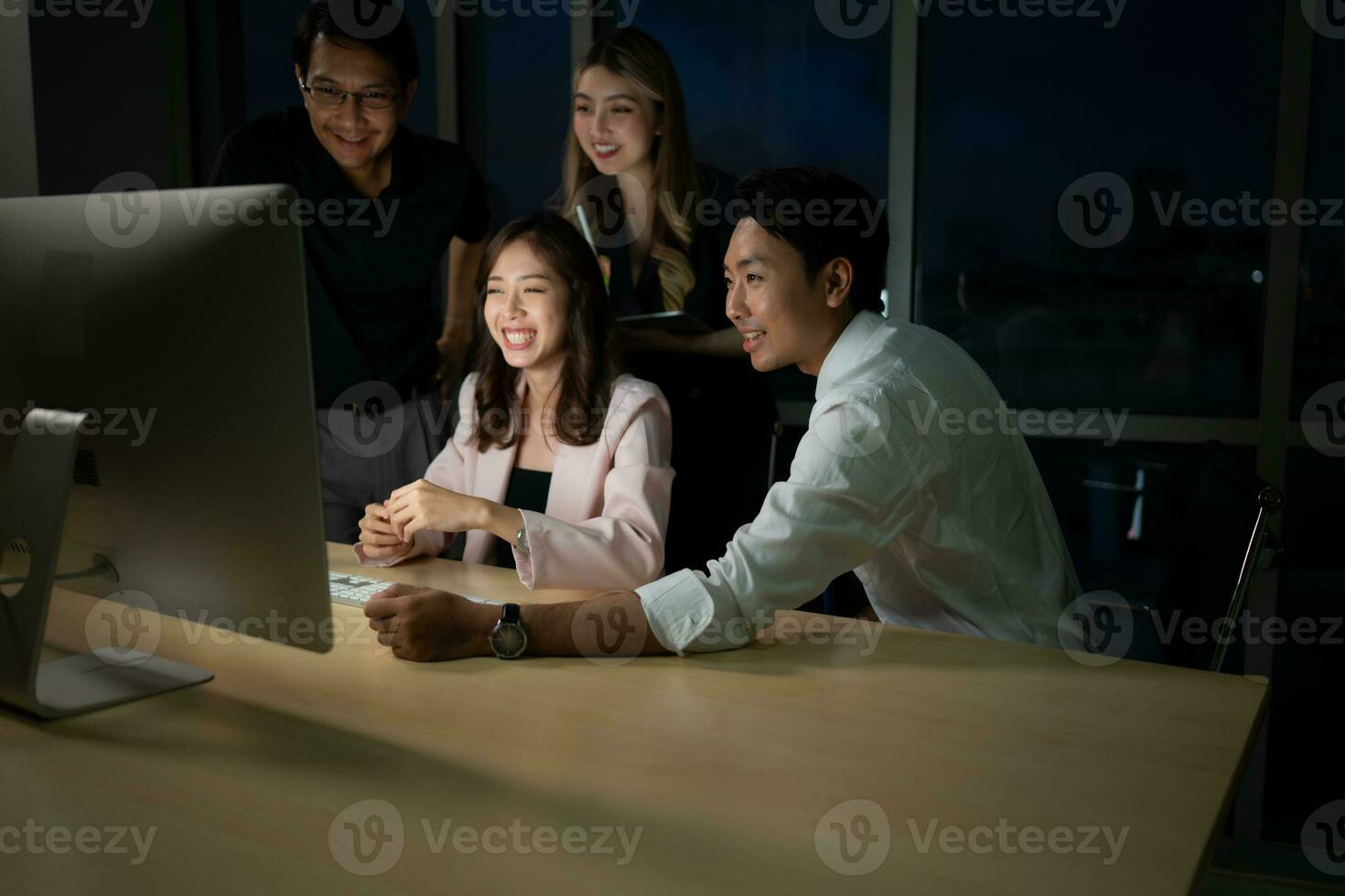 Group of business people working in office at night. Business concept. photo