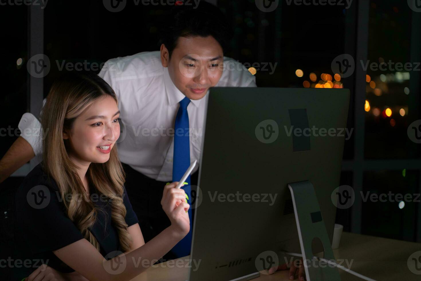 Both of young Asian broker international stock traders working together on desktop at night office, International financial investment company concept photo