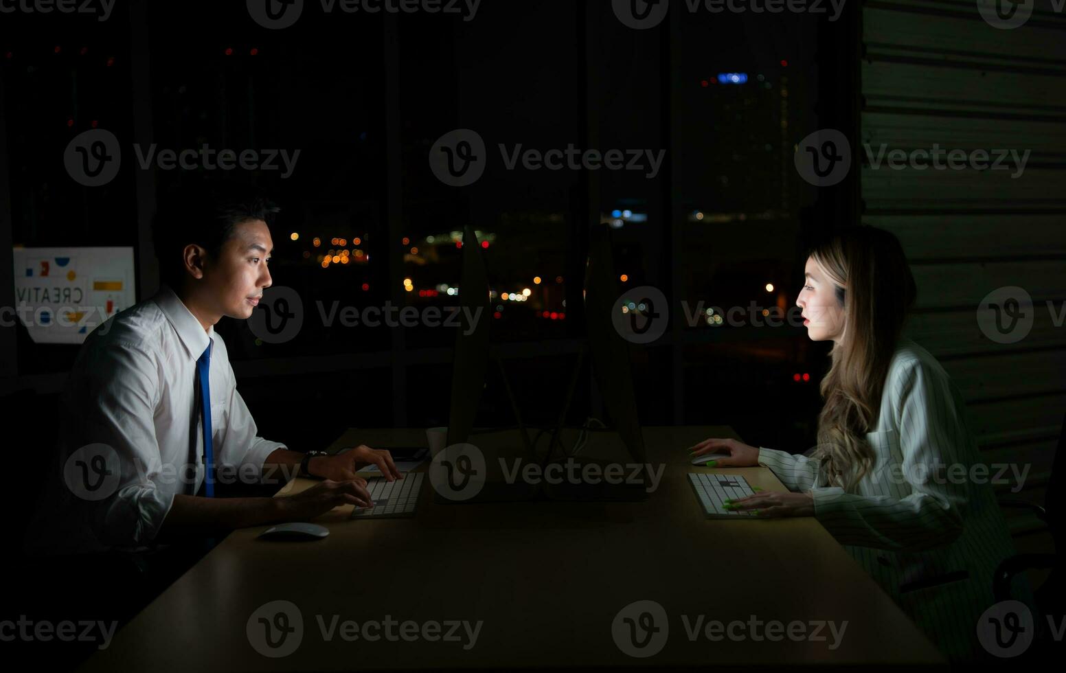Both of young Asian broker international stock traders working together on desktop at night office, International financial investment company concept photo