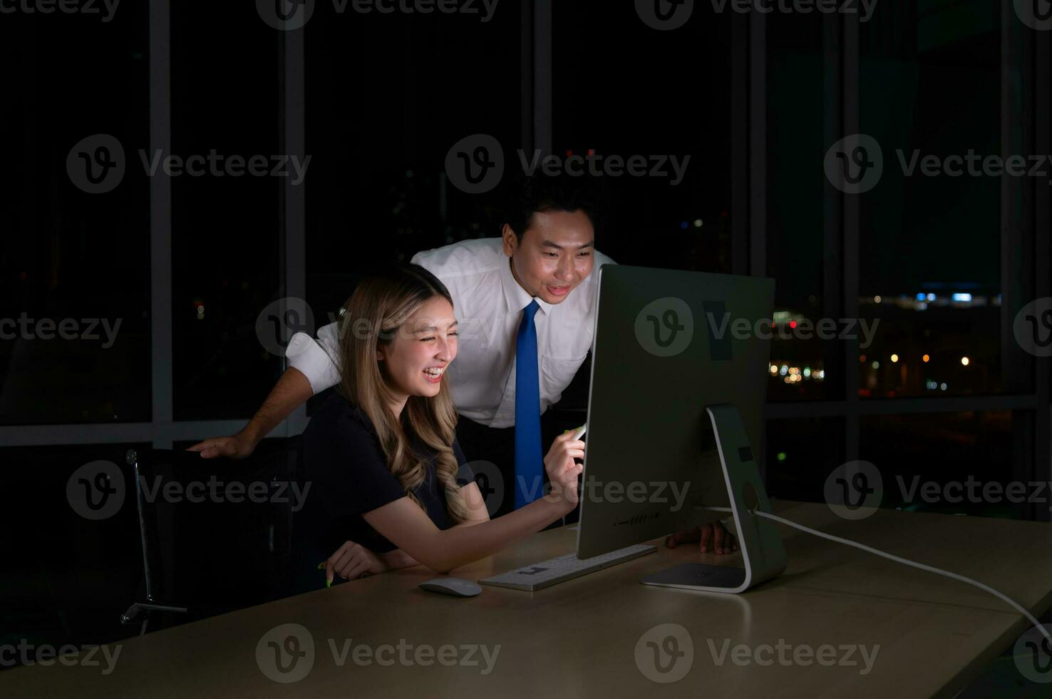 Both of young Asian broker international stock traders working together on desktop at night office, International financial investment company concept photo