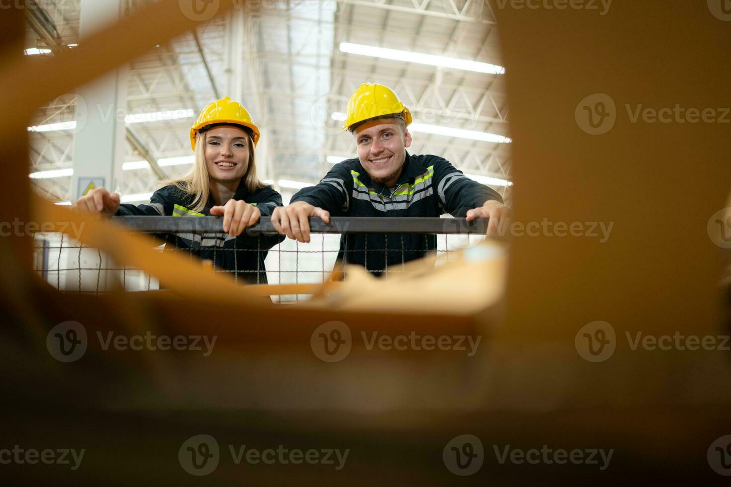 Two factory workers work in a warehouse, pushing a paper cart to be recycled photo