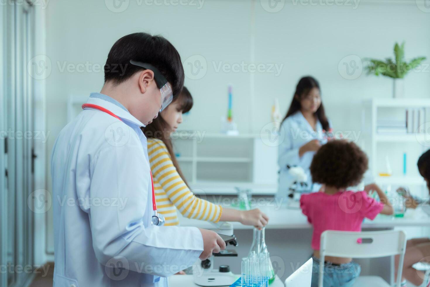 In the science classroom, an Asian child scientist experimenting with scientific formulas with chemicals photo